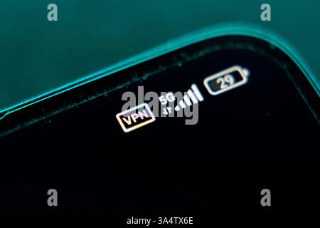 Nahaufnahme eines Smartphone-Bildschirms mit Symbolen für VPN, 5G-Netzwerk und Akku. Cybersicherheit, Datenschutz im Internet und mobiles Technologiekonzept. Stockfoto