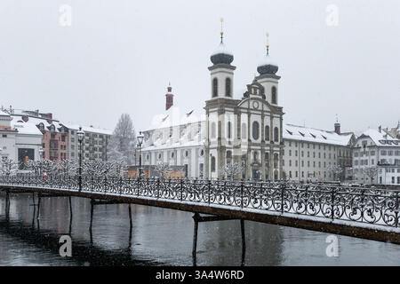 Jesuit Churchin Luzern, Schweiz, und eine Brücke über den Fluss Reuss im Vordergrund Stockfoto