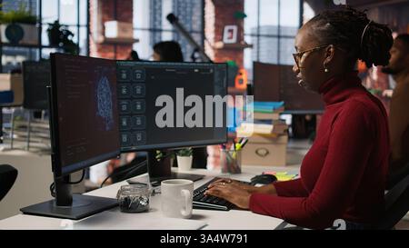 Silicon Valley Venture Programmierer löst Aufgaben mit KI LLM Chatbot unter Verwendung von Predictive-Technologie. afroamerikanischer IT-Startup-Mitarbeiter, der PC verwendet, um mit dem generativen Modell, Kamera A, zu interagieren Stockfoto