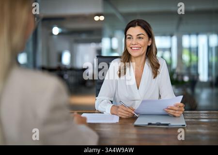 Glückliche, reife Geschäftsfrau HR-Managerin, die ein Vorstellungsgespräch im Büro führt. Stockfoto