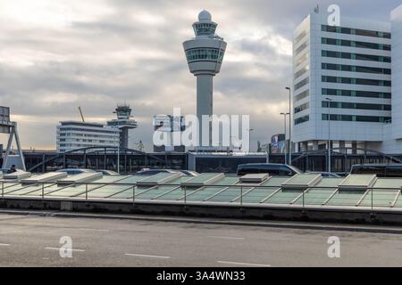 Flugsicherungsturm des Flughafens Schiphol und umliegende Gebäude an einem bewölkten Tag. Einer der verkehrsreichsten internationalen Flughäfen in Europa. Stockfoto