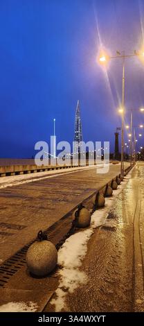 Sankt Petersburg, Russland - 19. März 2025: Fantastische Winterlandschaft bei Sonnenaufgang. Modernes Wolkenkratzer Lakhta Zentrum und Wanderwege im Park 300 Jahrestag von St. Petersburg. Vertikales Foto Stockfoto
