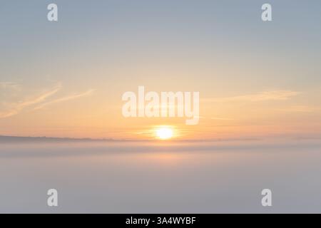 Sonnenaufgang, der sich im Nebel über den South Downs Way vom South Downs Way reflektiert, an einem Frühlingsmorgen im South Downs National Park Stockfoto