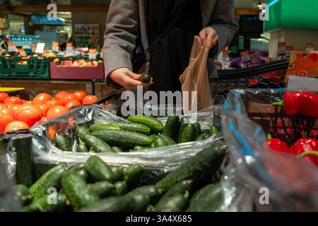 Person, die Gurken im Supermarkt auswählt Stockfoto