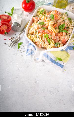 Frühlingsdiät gesunde vegane Pasta. Italienische Fusilli Pasta mit Tomaten, grünem Gemüse, frischen Kräutern, Frischkäse oder Feta, auf weißem Tischhintergrund c Stockfoto