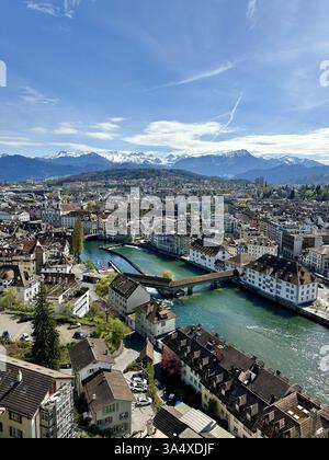 Dieser Blick vom Musegg-Mauerturm in Luzern aus fängt die historische Altstadt, die berühmte Spreuerbrücke und die majestätischen Berge ein Stockfoto