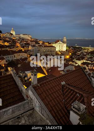 Ein abendlicher Blick vom Miradouro das Portas do Sol, Blick über Lissabons Stadtteil Alfama in Richtung Igreja de Santo Estêvão und anderer Sehenswürdigkeiten. Stockfoto