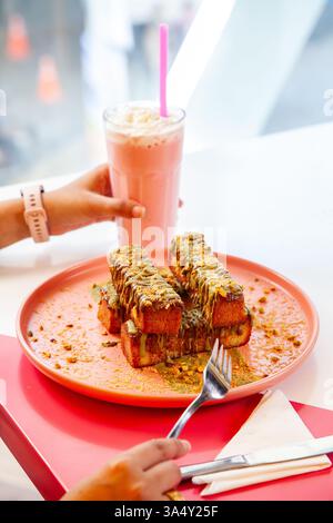 französischer Zimt-Toast mit Pistazienbelag, serviert mit Milchshake in einem schicken Café-Restaurant. Stockfoto