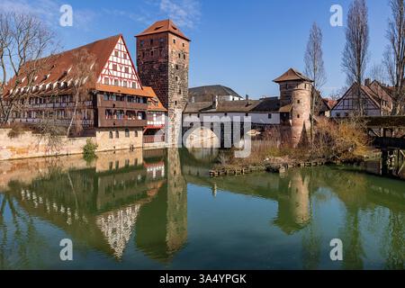 Nürnberger Stadtblick, 20.03.2025 der Weinstadel, die Henkersteg-Brücke und der Wasserturm spiegeln sich an einem sonnigen Frühlingsanfang in der Pegnitz. Die Fachwerkarchitektur und die historische Türme gehören zu den bekanntesten Wahrzeichen Nürnbergs. Erste grüne Blätter und Blüten kündigen den Frühling an. Nürnberg Altstadt - Saint Lorenz Bayern Deutschland *** Nürnberger Stadtansicht, 20 03 2025 der Weinstadel, die Henkersteg-Brücke und der Wasserturm spiegeln sich in der Pegnitz in einem sonnigen Frühfrühling wider die Fachwerkarchitektur und die historischen Türme gehören zu den berühmtesten Nürnberger Stockfoto