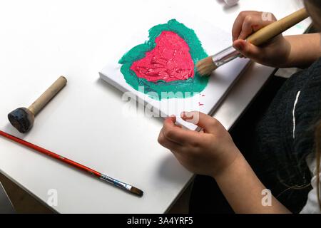 Das Kind malt ein rotes Herz Stockfoto