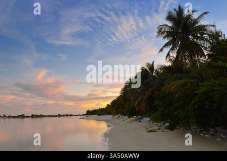Ruhige Niemandsszene mit tropischen Wasservillen auf einer Insel der Malediven unter hellblauem Himmel. Dieses luxuriöse Resort ist ideal für Reisekampagnen, Inselausflüge und erstklassige Urlaubsinhalte. Ideal für exotische Reiseziele, Villen am Meer und ruhige Strandausflüge. Stockfoto