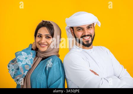 Familie aus dem Nahen Osten in traditionellem emiratischem Kleid, die in einem Fotostudio posiert und Lebensstil, Glück und Familienbande vermittelt. Ideal für Kultur, Familienwerte und regionalen Stil. Stockfoto