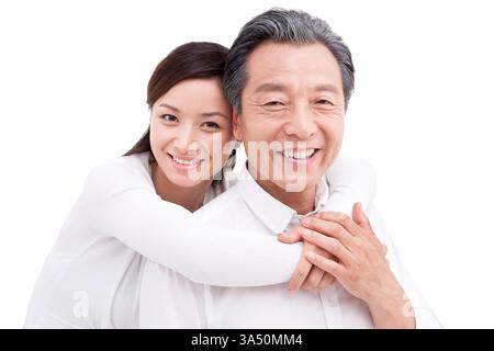 Warmes Studio-Porträt eines glücklichen chinesischen Vaters mit seiner Tochter, der einen zärtlichen Moment der Zweisamkeit einfängt. Betont Vaterschaft, Familienbande und generationenübergreifende Zuneigung in China. Geeignet für Eltern, Familienleben und Kampagnen für das Familienleben in Ostasien. Stockfoto