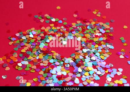 Kleine Glitzerherzen umgeben einen Bereich, der ein großes Herz bildet. Stockfoto