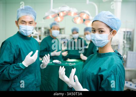 Porträt chinesischer Chirurgen im Operationssaal, fokussiert auf einen chirurgischen Eingriff. Das Bild zeigt medizinisches Fachpersonal, Teamarbeit und eine sterile Arbeitsumgebung. Stockfoto