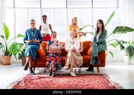 Gruppe selbstbewusster Geschäftsfrauen, die in einem modernen Büro Brainstorming machen. Verschiedene Kollegen arbeiten zusammen, um Ideen zu entwickeln und Probleme zu lösen. Geeignet für Themen wie weibliche Führung, Teamarbeit und integrative Arbeitsplätze. Stockfoto
