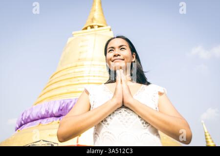 Thai-Frau betet in einem buddhistischen Tempel. Bild des kulturellen und spirituellen Lebensstils, geeignet für Reise-, Religions- und Tempelfotografie. Ideal für südostasiatische Grafiken und historische Kontexte. Stockfoto