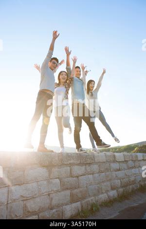 Glückliche chinesische Freunde genießen die Zeit im Freien in den Vororten. Dieses fröhliche Lifestyle-Bild für Gruppen passt zu Kampagnen über Freundschaft, Outdoor-Aktivitäten und zwanglose Treffen. Ideal für multikulturelle, Jugendliche Lifestyle-Grafiken. Stockfoto