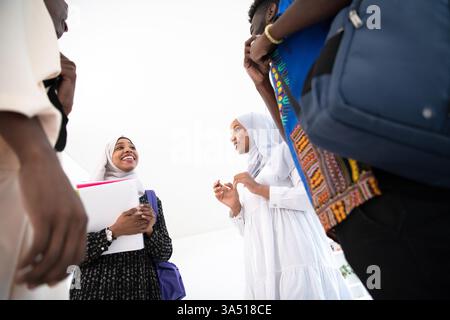 Gruppe verschiedener Studenten im Hijab, die während eines Teammeetings an der Universität zusammenarbeiten. Sie studieren zusammen mit Notebooks und Laptops und zeigen Teamarbeit und moderne Bildung. Eine gute Wahl für Bildung, Vielfalt und das Studentenleben. Stockfoto