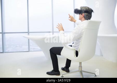 Chinesischer Geschäftsmann mit VR-Brille im Büro Stockfoto