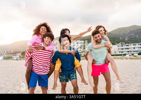 Lebhafte multikulturelle Gruppe von Freunden, die einen sonnigen Sommer im Freien genießen. Sie teilen sich Lachen und Kameradschaft auf einem Strandurlaub und tragen legere Sommeroutfits, die unbeschwerte Reisearten vermitteln. Diese lebendige Lifestyle-Aufnahme ist ideal für Kampagnen über Freundschaft, Urlaub und Freizeit im Freien. Stockfoto