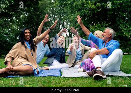Eine Outdoor-Szene einer vielfältigen Gruppe älterer Freunde, die gemeinsam Zeit in London in der Nähe von Westminster und St. James's Park genießen. Das zwanglose Treffen strahlt Freundschaft, Glück und Lachen aus, während sie in der Hauptstadt plaudern und lächeln. Ein warmes Lifestyle-Image, das sich für Reisen, Tourismus und gesellschaftliche Momente in London eignet. Stockfoto