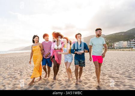 Gruppe junger, multikultureller Freunde, die sich in einem sonnigen Sommerurlaub im Freien verbünden. Lebendiges Lifestyle-Bild für Freundschaft, Reisen und Outdoor-Spaß. Ideal für Urlaubs-, Jugend- und Sommerausflüge. Stockfoto