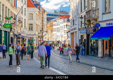 Brüssel, Belgien, 7. Juli 2023: Menschen Touristen gehen die Fußgängerzone mit vielen Geschäften, Geschäften, mittelalterlichen Häusern und alten Gebäuden entlang Stockfoto