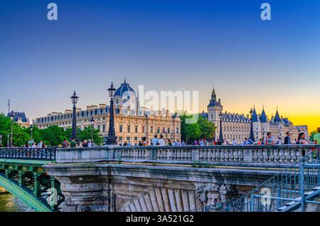 Paris, Frankreich, 8. Juli 2024: Viele Touristen auf der Brücke Pont Notre-Dame in der Altstadt von Paris bei Sonnenuntergang, Conciergerie Palast und Tribunal Stockfoto
