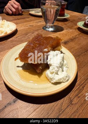 Ekmek kadayifi Brot Kadayif mit Sahne, türkisches traditionelles Brotdessert, köstlich mit Sherbet, serviert im lokalen Restaurant Stockfoto