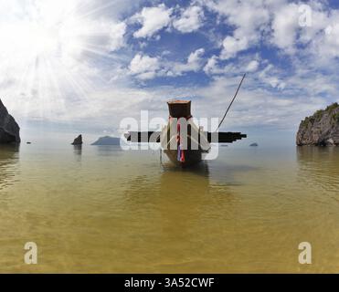 Das bekannte Thai-Boot Longtail wird von einem Anker auf Sand vertäut. Ein malerischer Sandstrand auf der Ozeaninsel. Thailand Stockfoto