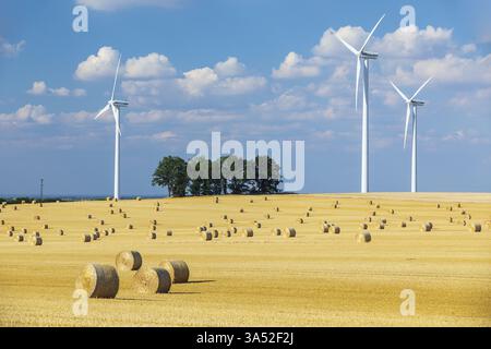 Strohballen auf einem geernteten Getreidefeld, Stoppelfeld, Windturbinen im Hintergrund, Nossen, Sachsen, Deutschland, Europa Stockfoto