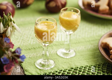 Zwei Gläser Eiecognac mit Frühlingsblumen, Nahaufnahme Stockfoto