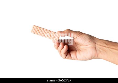 Männliche Hand, die einen rosafarbenen Waffelkeks auf weißem Hintergrund hält Stockfoto
