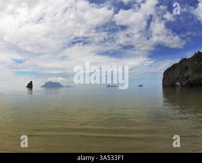 Flacher Sandstrand. Die malerische Bucht im Golf von Thailand ist von Inseln umgeben - Felsen verschiedener Formen. Nebeliger Morgen nach einem schweren Sturm Stockfoto