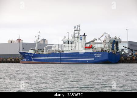 Reykjavik, Island - 4. April 2017: Ein blaues industrielles Fischereischiff, das in einem modernen Hafen mit modernen Einrichtungen und Strukturen stationiert ist Stockfoto