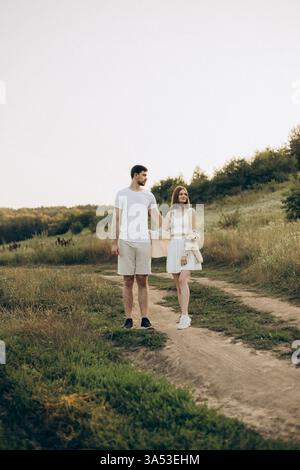 Ein Paar geht Hand in Hand durch eine wunderschöne Wiese und verkörpert Romantik und Ruhe in sanfter Umarmung der Natur, perfekt für die Aufnahme des Lebensstils A Stockfoto