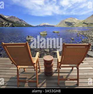 Der komfortable Ort, um die Schönheit des Sees und der Wolken in Patagonien zu genießen. Zwei zusammenklappbare Holzstühle und ein kleiner Nachttisch auf der Promenade Stockfoto