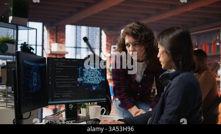 Der Ingenieur des KI-Startups stellt Fragen an den Teamleiter, bevor er mit der Implementierung von maschinellem Lernen beginnt. Ein Mitarbeiter des technischen Risikos für künstliche Intelligenz bittet den Manager um Hilfe bei der Behebung von Codefehlern, Kamera A Stockfoto