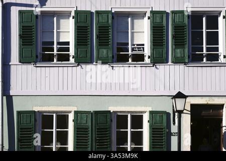 Ein Reihenhaus mit nostalgischen Holzläden und einer Laterne Stockfoto