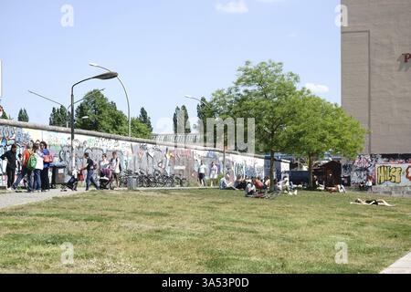 Berlin, Deutschland - 09. Mai 2016: Touristen besuchen und Jugendliche sonnen sich am 9. Mai 2016 auf dem Rasen hinter der East Side Gallery in Berlin Stockfoto
