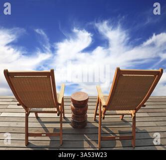 Der komfortable Ort, um die Schönheit der Wolken in Patagonien zu genießen. Zwei zusammenklappbare Holzstühle und ein kleiner Nachttisch auf der Promenade Stockfoto