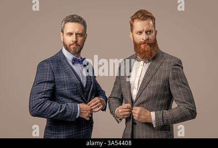 Zwei Männer in eleganter Herrenmode mit Anzug und Schleife isoliert auf Grau Stockfoto