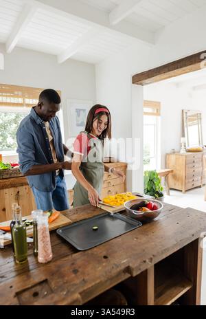 Frisches Gemüse zubereiten, verschiedene Paare kochen zusammen in gemütlicher Küche im Urlaub Stockfoto