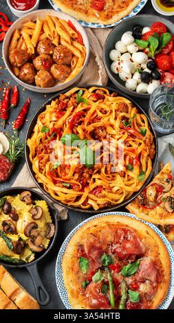 Italienisches Speisesortiment auf dunklem Hintergrund. Traditionelles kulinarisches Konzept. Gerichte und Vorspeisen. Draufsicht. Stockfoto