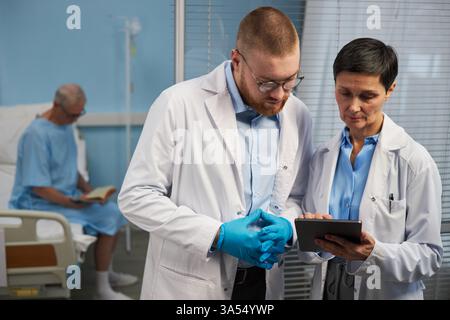 Medizinische Fachkräfte diskutieren Patientenakten im Krankenhaus Stockfoto