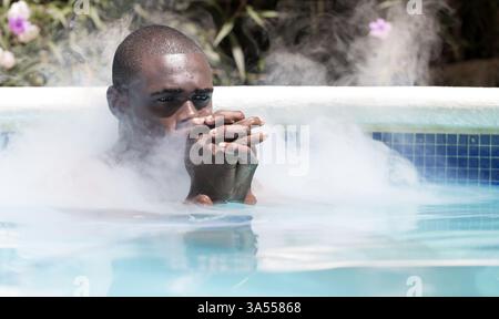 Mann meditiert im Dampfbad Stockfoto