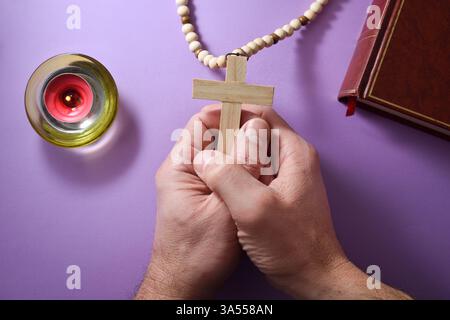 Christian betet mit erhobenen Händen und schwarzem Tisch im Hintergrund mit der bibel. Erhöhte Aussicht. Stockfoto