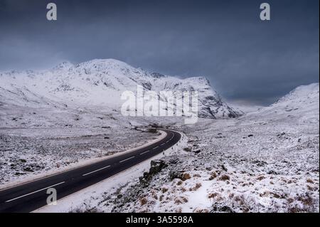 Schottisches Hochland und schneebedeckte Berge mit einer Straße Stockfoto