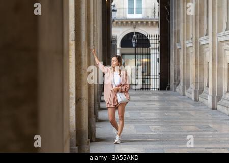 Frau, die an einer alten Säule in der Nähe des Museums steht und sich beugt Stockfoto